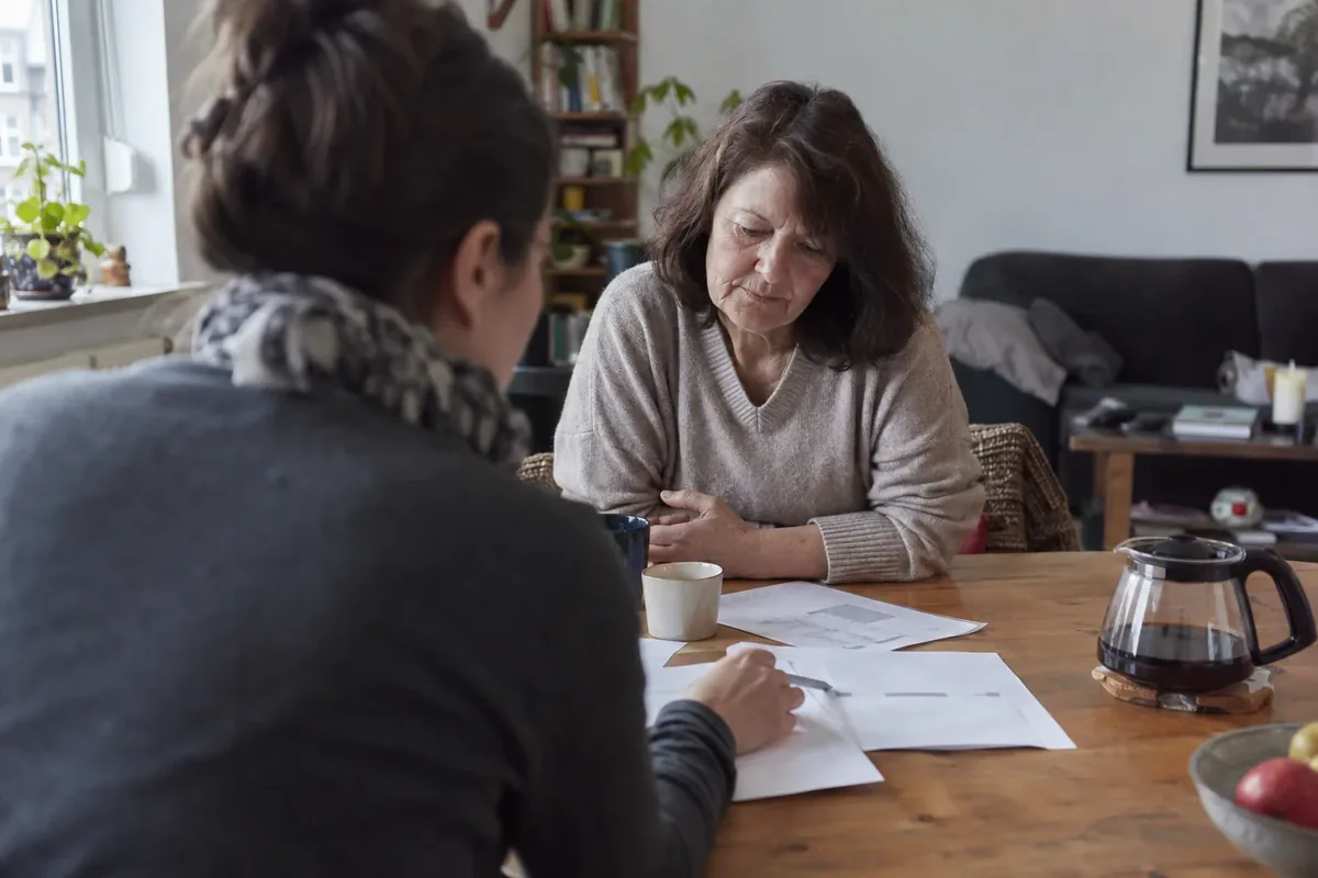 Beratungsgespräch mit Unterlagen am Wohnzimmertisch